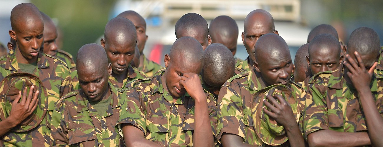 Kenya Defence Forces soldiers bow their heads during a memorial service for slain soldiers killed in southwest Somalia's el-Adde region by al-Qaeda linked Somali based Islamists, al-Shabaab. Nairobi, Kenya, January 27, 2016. (Tony Karumba/AFP/Getty Images)