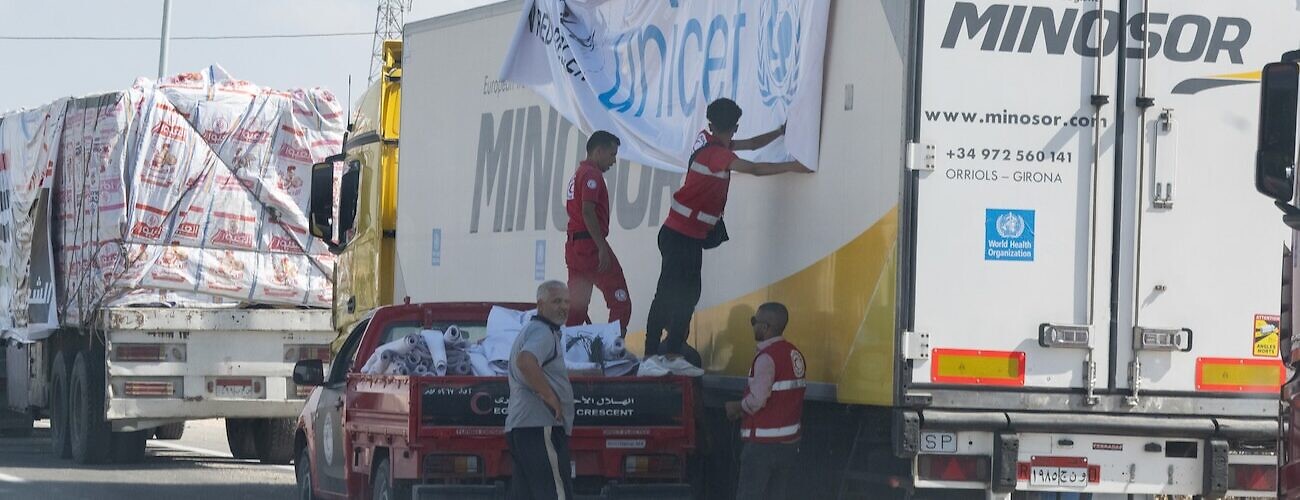 Aid workers load humanitarian supplies onto a truck near the Rafah border crossing between Egypt and Gaza