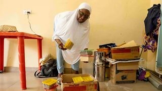 A health worker at a primary healthcare center on the outskirts of Maiduguri shows the food grains she distributes